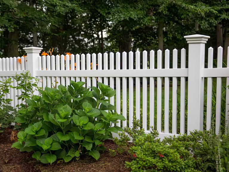 well-maintained white picket fence in a garden setting, crafted by Premier Outdoor Solutions.